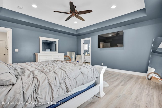 bedroom with connected bathroom, light hardwood / wood-style flooring, and ceiling fan