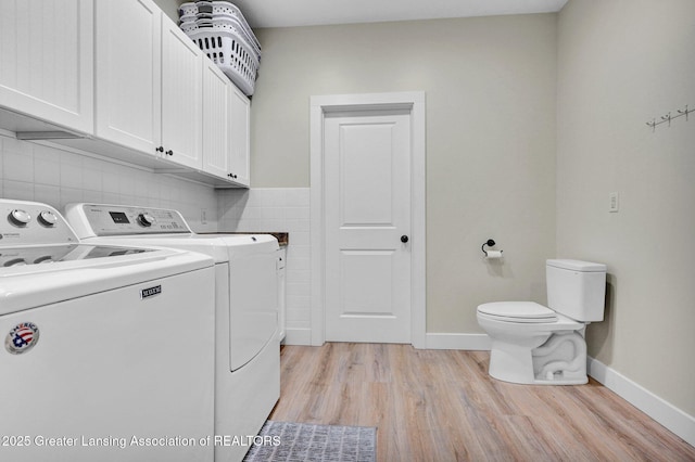 washroom with separate washer and dryer and light hardwood / wood-style flooring