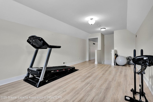 workout area featuring vaulted ceiling and light wood-type flooring