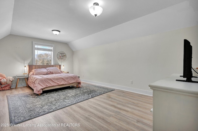 bedroom featuring vaulted ceiling and light hardwood / wood-style flooring