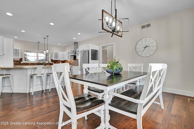 dining room with dark hardwood / wood-style floors, a chandelier, and sink