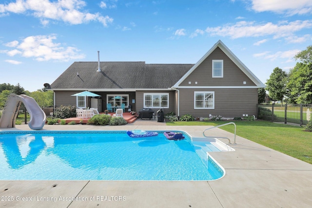 view of swimming pool with area for grilling, a yard, a water slide, and a patio