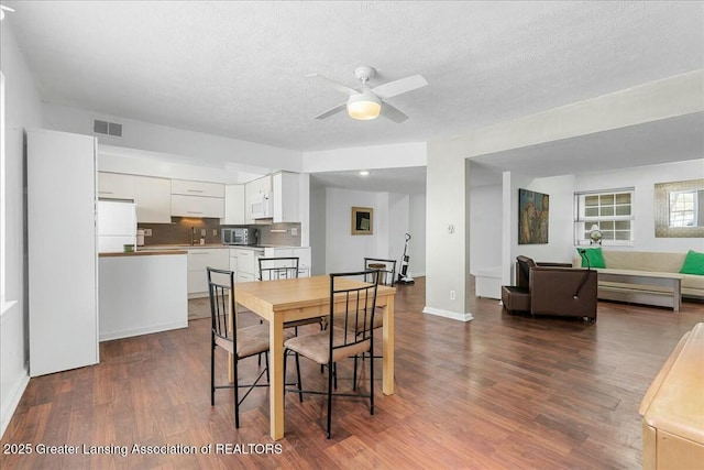 dining room with ceiling fan, a textured ceiling, and dark hardwood / wood-style flooring