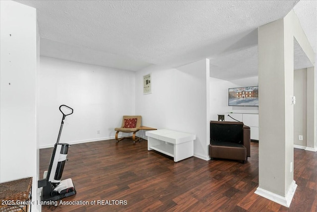 living area featuring dark hardwood / wood-style flooring and a textured ceiling