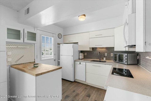 kitchen featuring white appliances, sink, decorative backsplash, and white cabinets