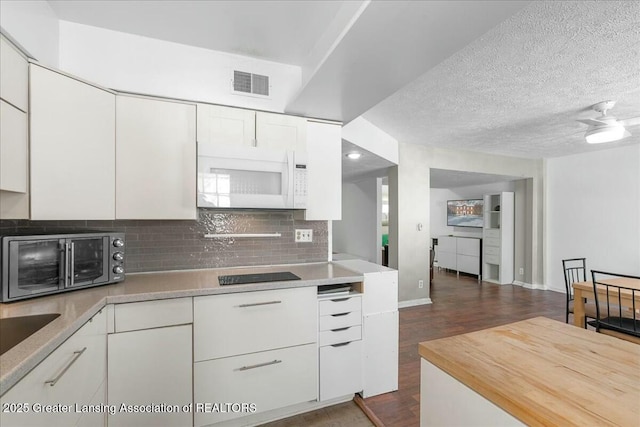 kitchen featuring white cabinetry, black electric cooktop, tasteful backsplash, and a textured ceiling