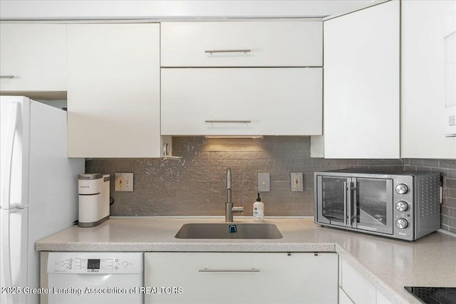 kitchen with white cabinetry, sink, and white appliances