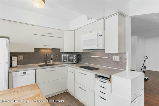 kitchen with sink, white appliances, dark hardwood / wood-style floors, white cabinets, and decorative backsplash