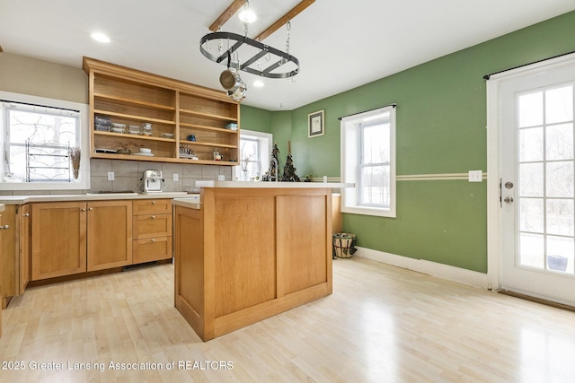 kitchen with light hardwood / wood-style floors, a center island, and decorative backsplash