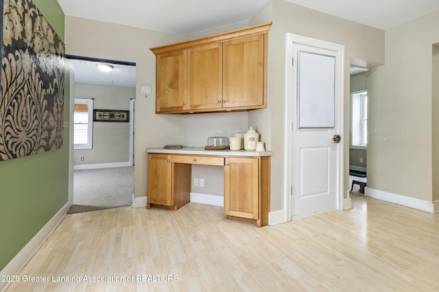 kitchen featuring light hardwood / wood-style flooring and built in desk