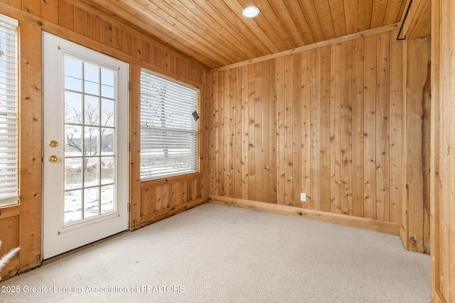 spare room with carpet flooring, wooden ceiling, and wood walls