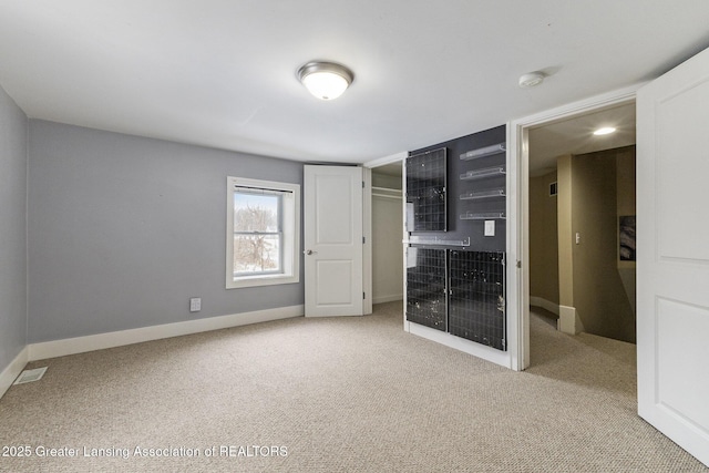 unfurnished bedroom featuring a closet and light colored carpet