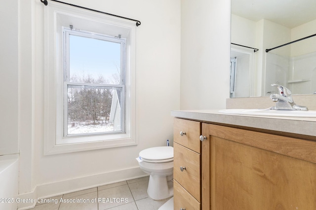 bathroom with toilet, vanity, and tile patterned flooring