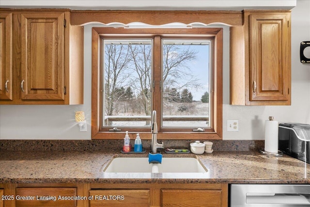 kitchen with dishwasher, sink, and light stone counters