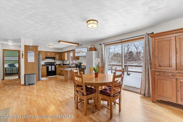 dining area featuring a textured ceiling and light wood-type flooring