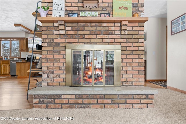 details with a brick fireplace, hardwood / wood-style flooring, stainless steel dishwasher, and sink