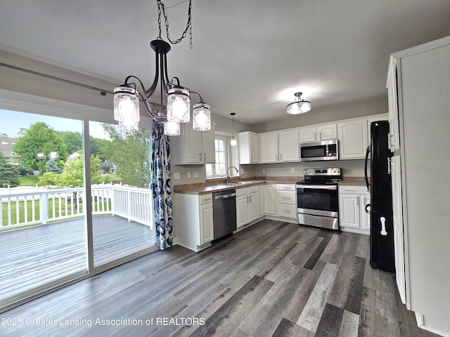 kitchen with pendant lighting, dark hardwood / wood-style flooring, white cabinets, and appliances with stainless steel finishes