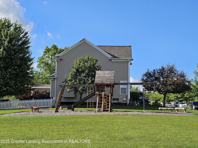 back of property with a playground and a lawn