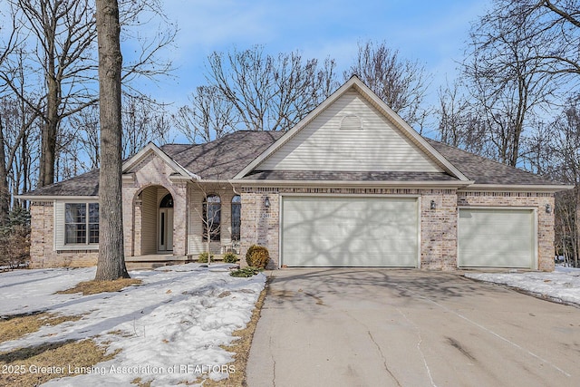 view of front facade with brick siding, driveway, an attached garage, and roof with shingles