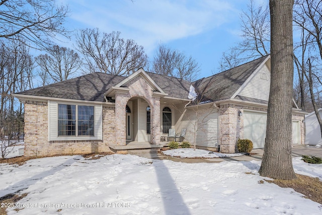 view of front of property featuring a garage, brick siding, roof with shingles, and a porch