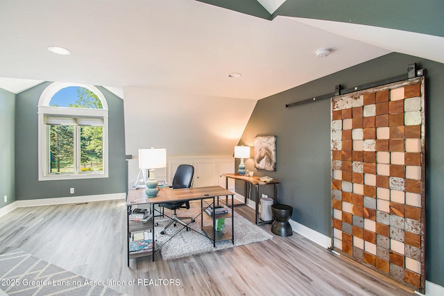 8955 W Braden Rd, Haslett, MI 48840 - office featuring vaulted ceiling, a barn door, and light hardwood / wood-style floors