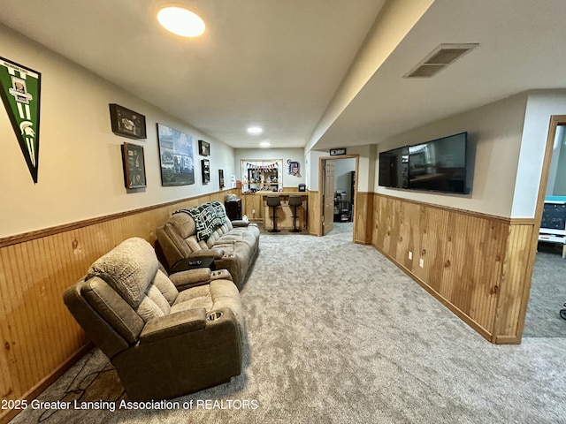 carpeted living room with wooden walls