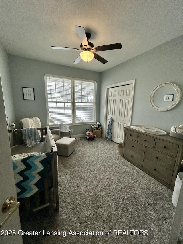 carpeted bedroom with a textured ceiling, ceiling fan, and a closet