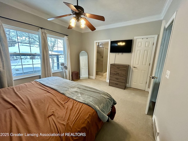 bedroom with crown molding, light colored carpet, ceiling fan, and ensuite bathroom