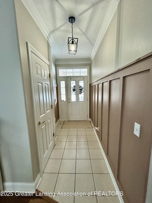 entryway featuring ornamental molding and light tile patterned floors