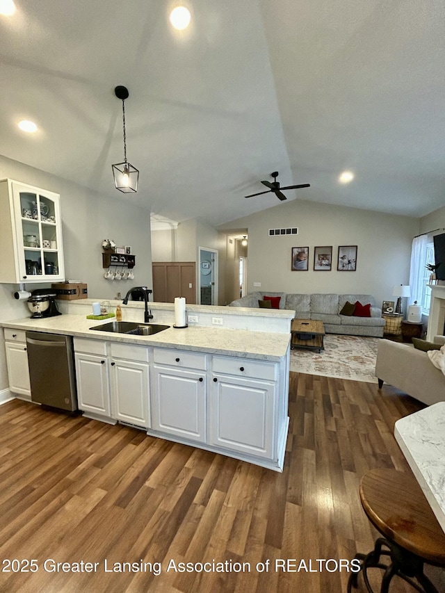 kitchen featuring hanging light fixtures, dishwasher, sink, and white cabinets