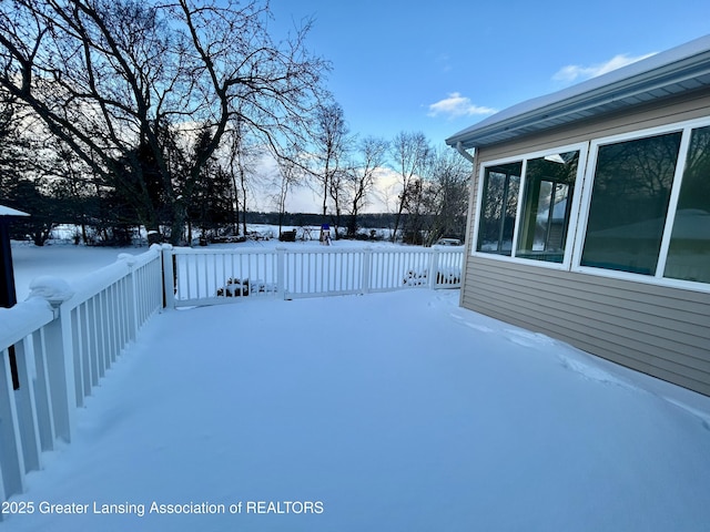 yard covered in snow with a wooden deck