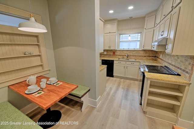 kitchen featuring stainless steel electric range oven, sink, black dishwasher, white cabinetry, and decorative light fixtures