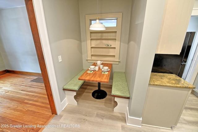 dining room featuring light hardwood / wood-style flooring and built in features