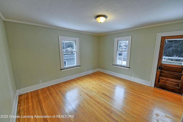 empty room with plenty of natural light, light hardwood / wood-style flooring, and ornamental molding