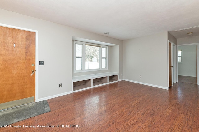 unfurnished living room with dark wood-type flooring