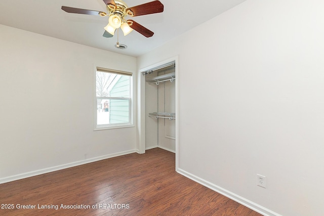 unfurnished bedroom with dark wood-type flooring, ceiling fan, and a closet