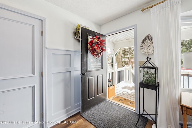 doorway to outside featuring wood-type flooring and a textured ceiling