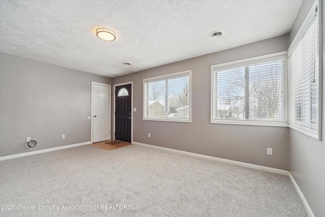 spare room featuring carpet floors and a textured ceiling