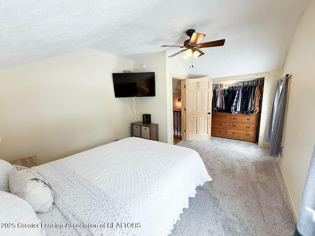 carpeted bedroom featuring ceiling fan, a textured ceiling, a closet, and lofted ceiling