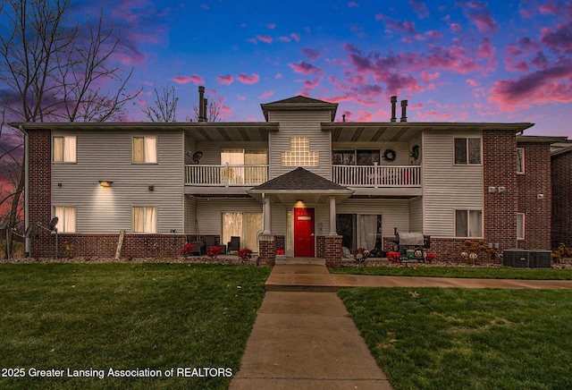 view of front of house featuring a yard and a balcony