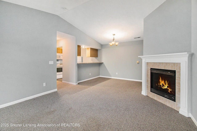 unfurnished living room featuring light carpet, lofted ceiling, a chandelier, and a fireplace