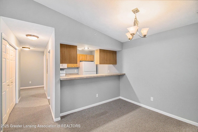 kitchen featuring white appliances, vaulted ceiling, kitchen peninsula, hanging light fixtures, and light carpet