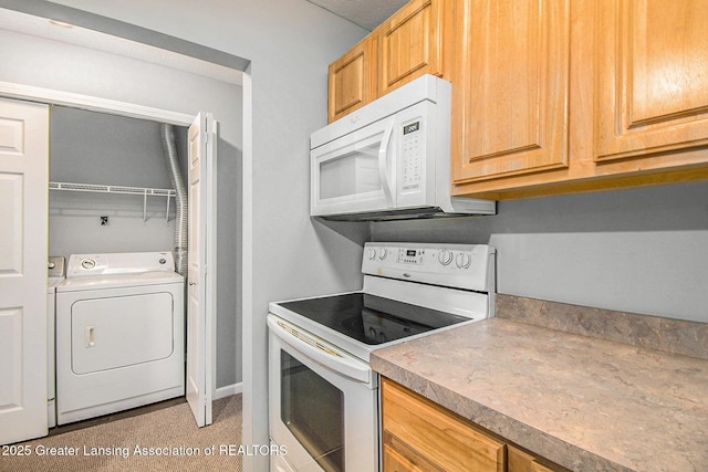 kitchen with white appliances and washer / dryer