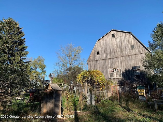 7761 W Herbison Rd, Dewitt, MI 48820 - view of side of home featuring a barn, a gambrel roof, and an outbuilding