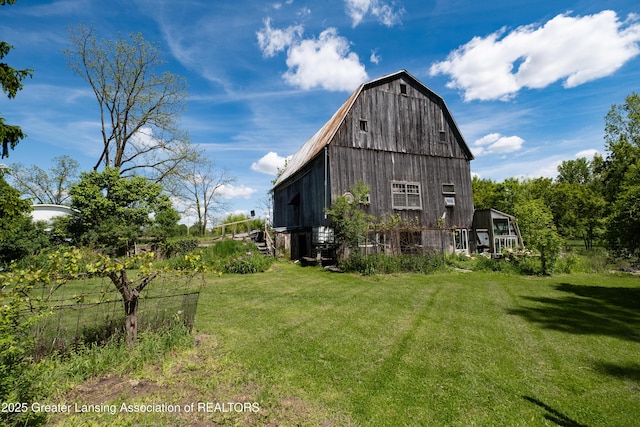 7761 W Herbison Rd, Dewitt, MI 48820 - view of property exterior featuring a barn, an outbuilding, a lawn, and a gambrel roof