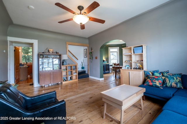 7761 W Herbison Rd, Dewitt, MI 48820 - living area featuring arched walkways, hardwood / wood-style floors, a ceiling fan, and baseboards