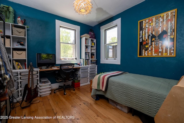 7761 W Herbison Rd, Dewitt, MI 48820 - bedroom with hardwood / wood-style floors, a chandelier, and a desk