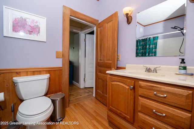 7761 W Herbison Rd, Dewitt, MI 48820 - bathroom with a wainscoted wall, toilet, vanity, wood finished floors, and a shower with shower curtain