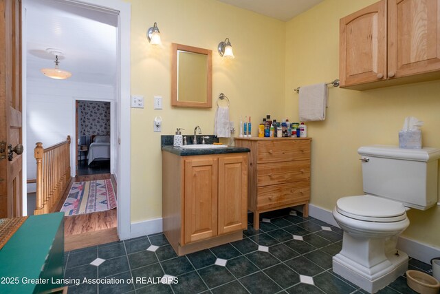 7761 W Herbison Rd, Dewitt, MI 48820 - ensuite bathroom featuring vanity, tile patterned flooring, toilet, and baseboards