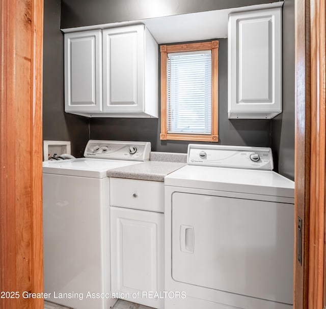 clothes washing area featuring cabinets and washing machine and dryer